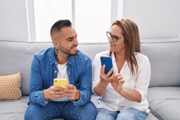 Man and woman mother and son using smartphone at home
