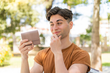 Young handsome man holding a wallet