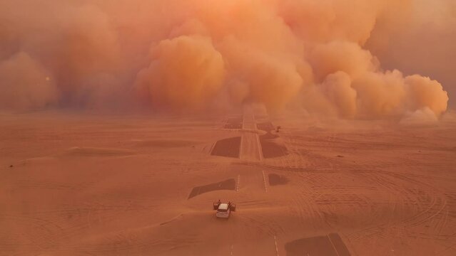 Two travellers on off road car looks to huge and epic sandstorm