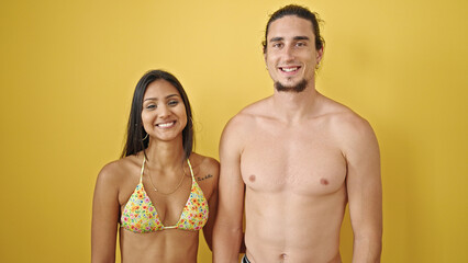 Fototapeta premium Man and woman tourist couple standing together smiling over isolated yellow background