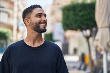 Young arab man smiling confident looking to the side at street