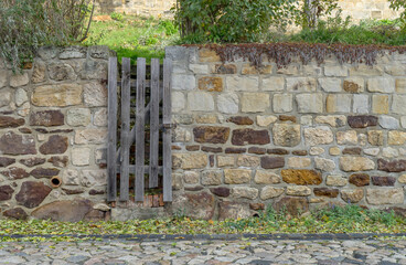 Wall on the Schlossberg in Quedlinburg made of rock stones with a narrow wooden door