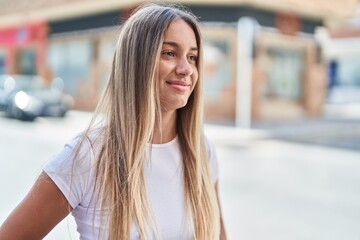 Young beautiful hispanic woman smiling confident looking to the side at street