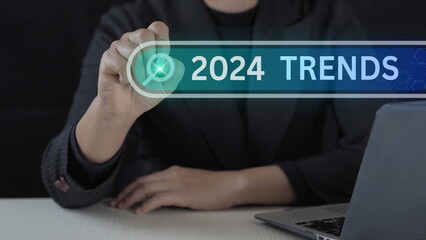 Businessman holding pen with 2024 trends searching bar for marketing monitor and business planning change concept.