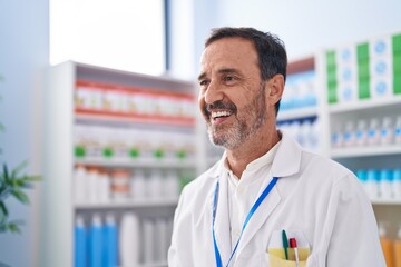 Middle age man pharmacist smiling confident standing at pharmacy
