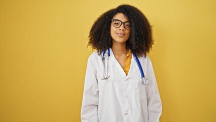African american woman doctor smiling confident standing over isolated yellow background