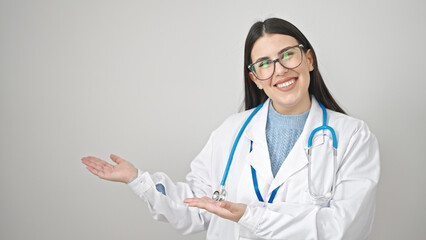 Young hispanic woman doctor smiling confident presenting over isolated white background