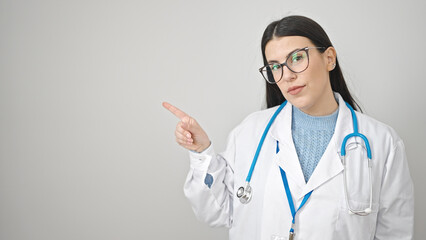 Young hispanic woman doctor pointing to the side over isolated white background