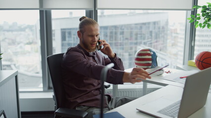 Inspired designer calling smartphone modern office closeup. Man using laptop