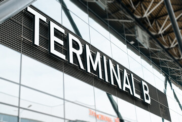 Obraz premium Side view of a large information sign with the text Terminal B airport building, close-up