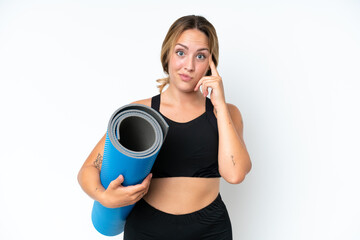 Young caucasian woman going to yoga classes while holding a mat isolated on white background thinking an idea