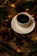 Obraz premium Coffee break on Christmas evening. A cup of espresso coffee on the table