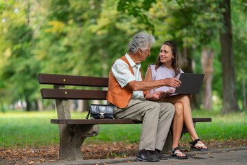 Caregiver helping senior man to shop online on notebook. The risk of online shopping scams targeting older people.