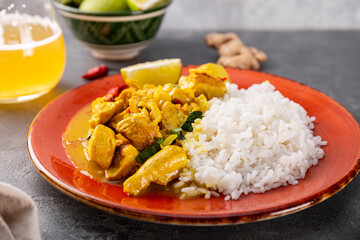 Chicken in curry sauce and rice on gray background, Indian food close up