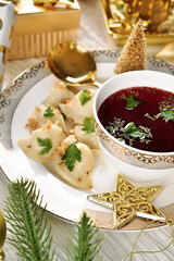 Closeup of traditional Christmas Eve red borscht with dumplings filled with mushrooms and sauerkraut