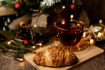 Croissant and tea. Pastries for Christmas. Fast food during the winter holidays