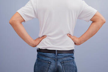 Man wearing white shirt showing back pain