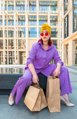 woman with craft shopping bags in the city. The concept of fashionable Consumerism and ecology. An...