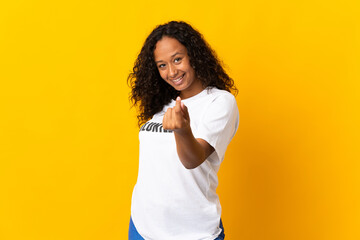 Teenager cuban volunteer girl isolated on yellow background making money gesture