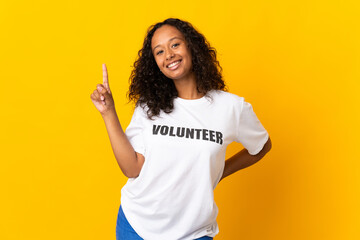 Teenager cuban volunteer girl isolated on yellow background showing and lifting a finger in sign of...