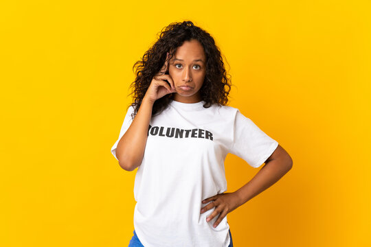 Teenager cuban volunteer girl isolated on yellow background thinking an idea