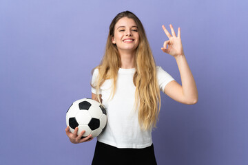 Young blonde football player woman isolated on purple background showing ok sign with fingers