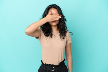 Young asian woman isolated on blue background covering eyes by hands. Do not want to see something