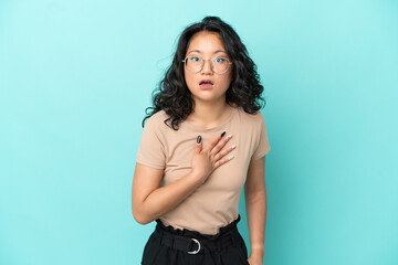 Young asian woman isolated on blue background surprised and shocked while looking right