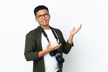 Young Ecuadorian photographer isolated on white background extending hands to the side for inviting...