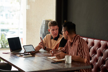 Team of trader discussing trading plan when meeting in coffeeshop