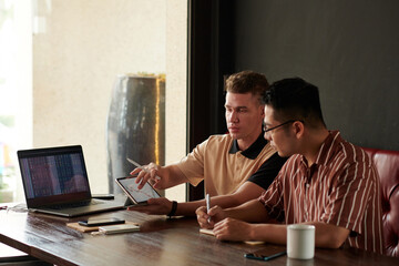 Traders analyzing various charts and discussing investing strategy