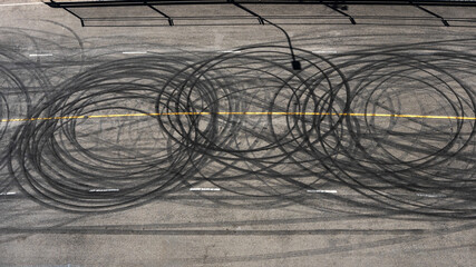Top view curving tire marks from professional car drifting on asphalt racing track, aerial view...