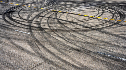 Top view curving tire marks from professional car drifting on asphalt racing track, aerial view...