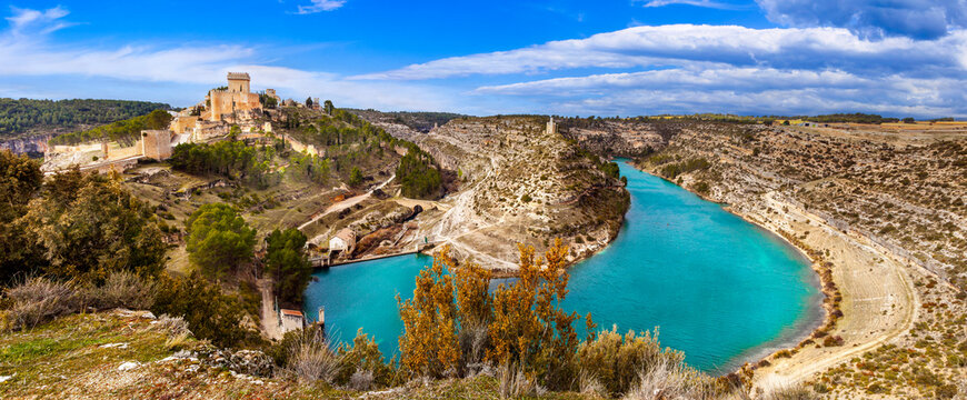 Spain Alarcon 10K panorama canyon view. Turquoise river and yellow steppe. Medieval castle on a hill. Castile-La Mancha. Historic fortress. Scenic travel