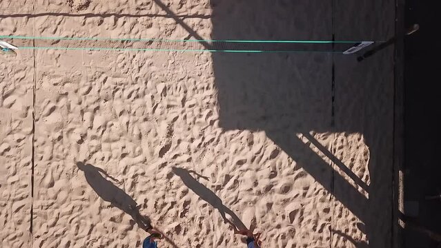 Cena a&eacute;rea de uma quadra de beach t&ecirc;nis com um jogo em andamento