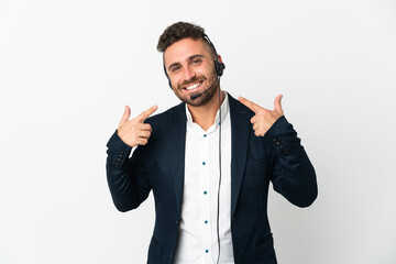 Telemarketer man working with a headset isolated on white background giving a thumbs up gesture