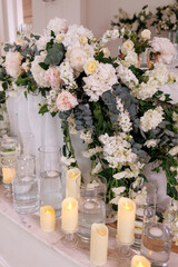 Obraz na płótnie Canvas Wedding ceremony. Presidium for the newlyweds, decorated with candles and vases with white and pink natural flowers such as eustoma, hydrangea, roses. Floristic concept