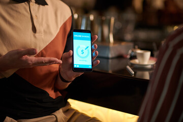 Cropped image of man showing phone screen to business partner when transferring him money