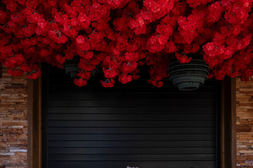 Vibrant red flowers hanging from the ceiling with  black textured traditional Chinese lanterns, ,...