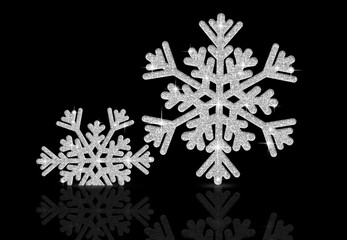 Two silver snowflakes on a black background. Christmas ornament.