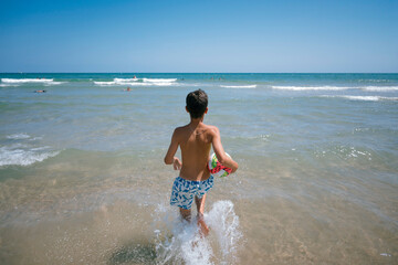 Teenage girl enjoying a fabulous day at the beach. She bathes in the sea.