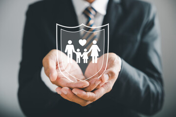Upholding family values, Businessman protective gesture complements young family silhouette. Health...