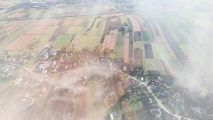 Aerial view of a rural landscape with patchwork fields and a small village. Sustainability concept.