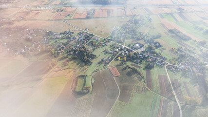 Aerial view of a rural landscape with patchwork fields and a small village. Sustainability concept.