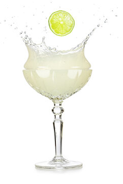 Lime slice falling into a splashing daiquiri or margarita cocktail isolated on white background.