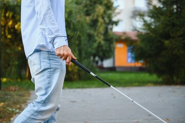 Blind Man Walking On Sidewalk Holding Stick.