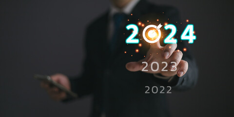Businessmen touch target 2024 and progress of business and analyze financial, and investment.Use technology to plan strategy to success goals and growth.online business, e-commerce, online marketing.