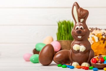 Easter chocolate bunny on a light texture table. Chocolate eggs and other sweets. Easter celebration concept. Easter sweets on the table. Place for text. copy space.