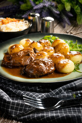 Traditional German braised pork cheeks in brown sauce.