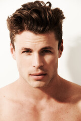 Obraz premium Hair, beauty and serious portrait of man in white background, studio and sunshine in morning. Skincare, dermatology and calm face of model with health, wellness and healthy glow in salon or spa